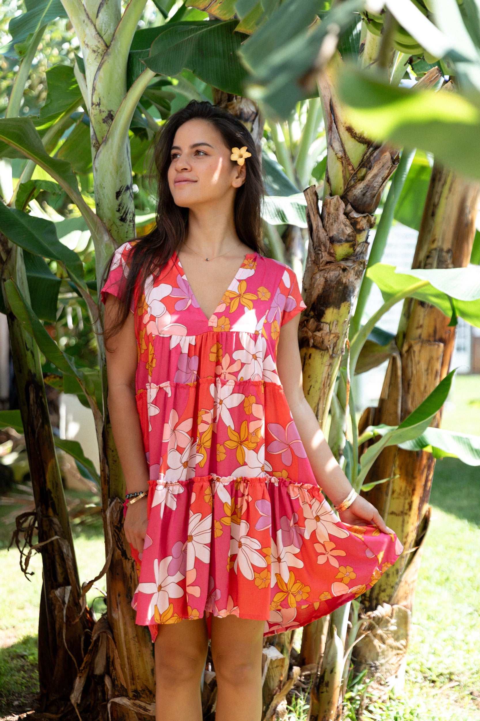 woman with brown hair wearing a pink short sleeve tiered mini dress with retro flower print