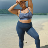 woman wearing a sports bra with blue hibiscus pattern and blue workout legging with pockets
