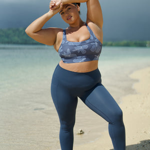 woman wearing a sports bra with blue hibiscus pattern and blue workout legging with pockets