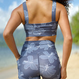 woman wearing a sports bra with blue hibiscus pattern