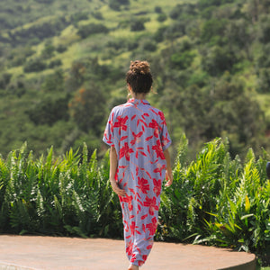 woman with brown hair wearing a maxi button up dress with periwinkle background and bright red hibiscus print.