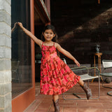 little girl wearing tie back dress with retro pink pua pattern