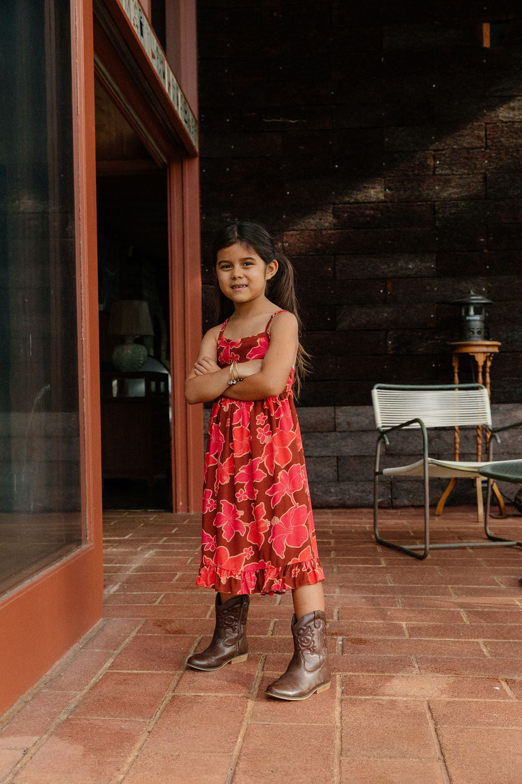 little girl wearing tie back dress with retro pink pua pattern