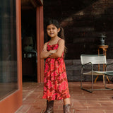 little girl wearing tie back dress with retro pink pua pattern