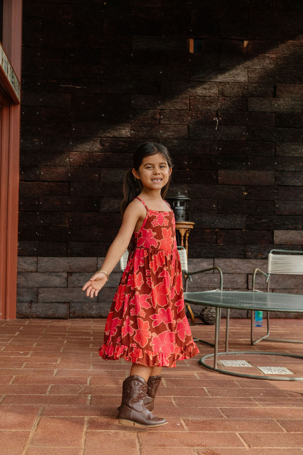 little girl wearing tie back dress with retro pink pua pattern