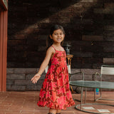 little girl wearing tie back dress with retro pink pua pattern