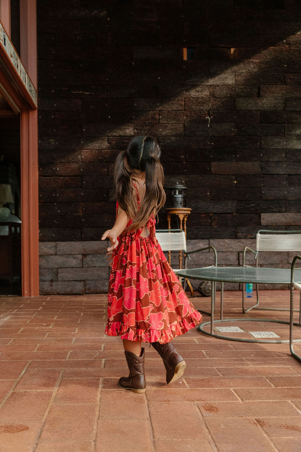 little girl wearing tie back dress with retro pink pua pattern