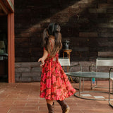 little girl wearing tie back dress with retro pink pua pattern