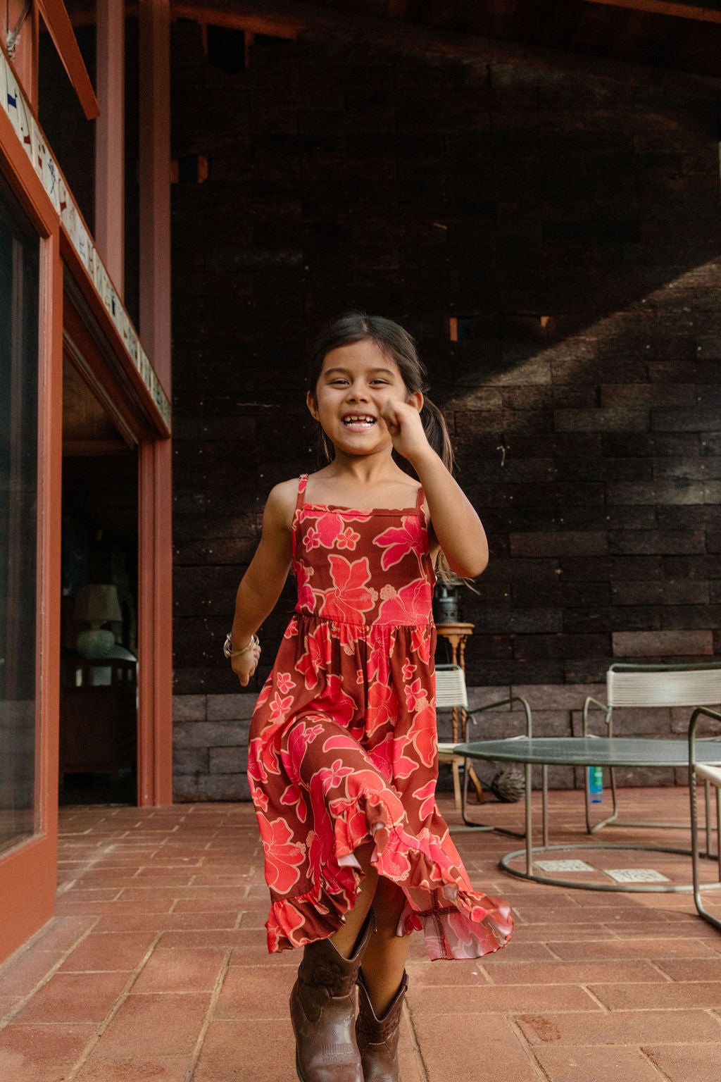 little girl wearing tie back dress with retro pink pua pattern