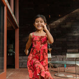 little girl wearing tie back dress with retro pink pua pattern