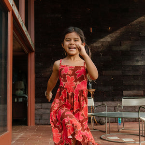little girl wearing tie back dress with retro pink pua pattern