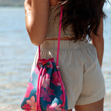 deep blue/teal neoprene drawstring crossbody purse with colorful floral pattern 