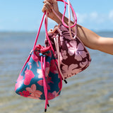 brown neoprene drawstring crossbody purse with pink hibiscus pattern