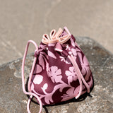 brown neoprene drawstring crossbody purse with pink hibiscus pattern