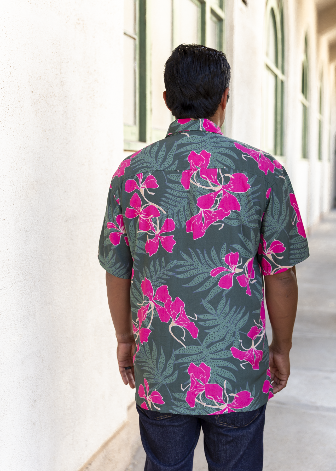 man with brown hair wearing men's aloha button up top with fern and ginger print