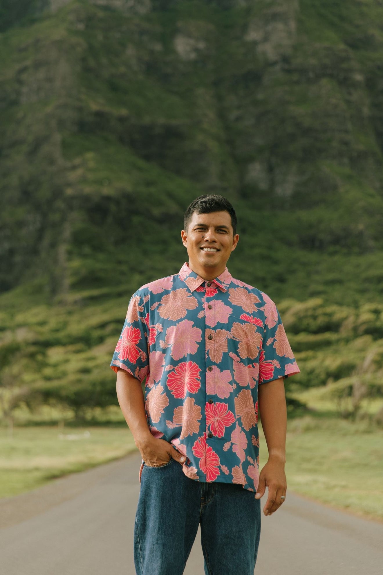 man wearing a nay button up aloha shirt with bright pink hibiscus print