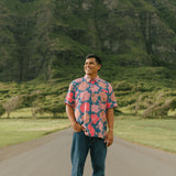 man wearing a nay button up aloha shirt with bright pink hibiscus print