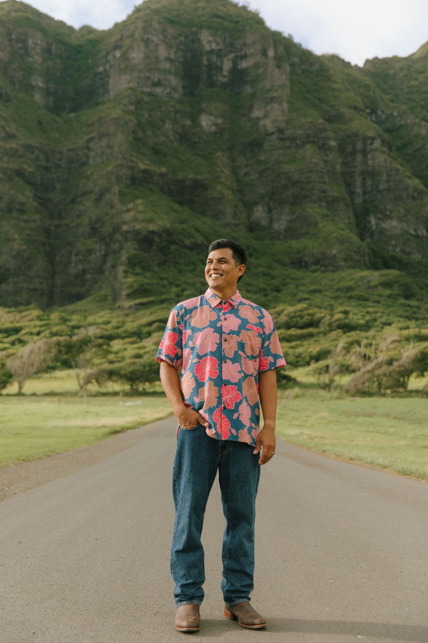 man wearing a nay button up aloha shirt with bright pink hibiscus print