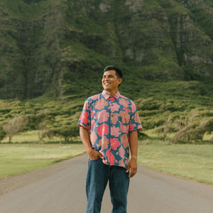 man wearing a nay button up aloha shirt with bright pink hibiscus print