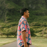 man wearing a nay button up aloha shirt with bright pink hibiscus print