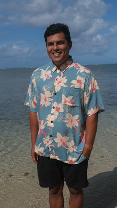 man wearing a teal aloha button up shirt with cream colored orchid pattern