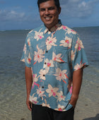 man wearing a teal aloha button up shirt with cream colored orchid pattern
