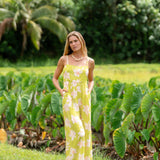 woman wearing a bright green tie back jumpsuit with orchid print