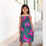 little girl with brown hair wearing a smocked spaghetti strap dress with fern and ginger print