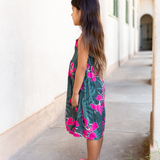 little girl with brown hair wearing a smocked spaghetti strap dress with fern and ginger print
