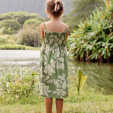 little girl wearing green smocked dress with native Hawaiian plants