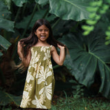  little girl wearing spaghetti strap dress in green print with naupaka pattern