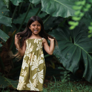  little girl wearing spaghetti strap dress in green print with naupaka pattern