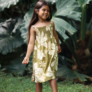 little girl wearing spaghetti strap dress in green print with naupaka pattern