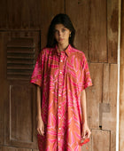 A woman with dark hair wears a YIREH collared, button-up dress. It is the Kaimana Dress in the Garden 'Awapuhi print. 