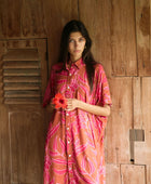 A woman with dark hair wears a YIREH collared, button-up dress. It is the Kaimana Dress in the Garden 'Awapuhi print. 