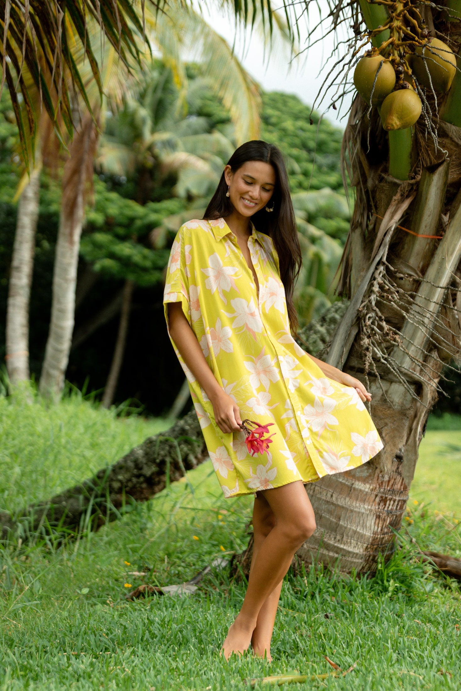 woman wearing a bright green button up dress with orchid print 