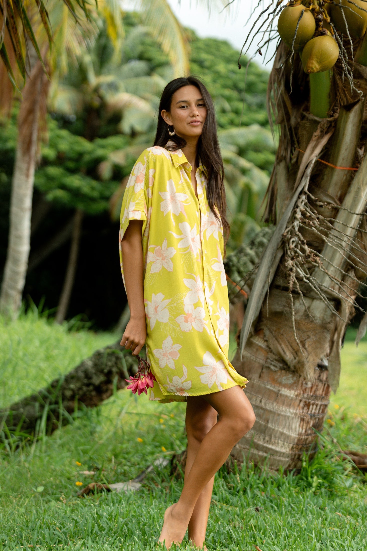 woman wearing a bright green button up dress with orchid print 