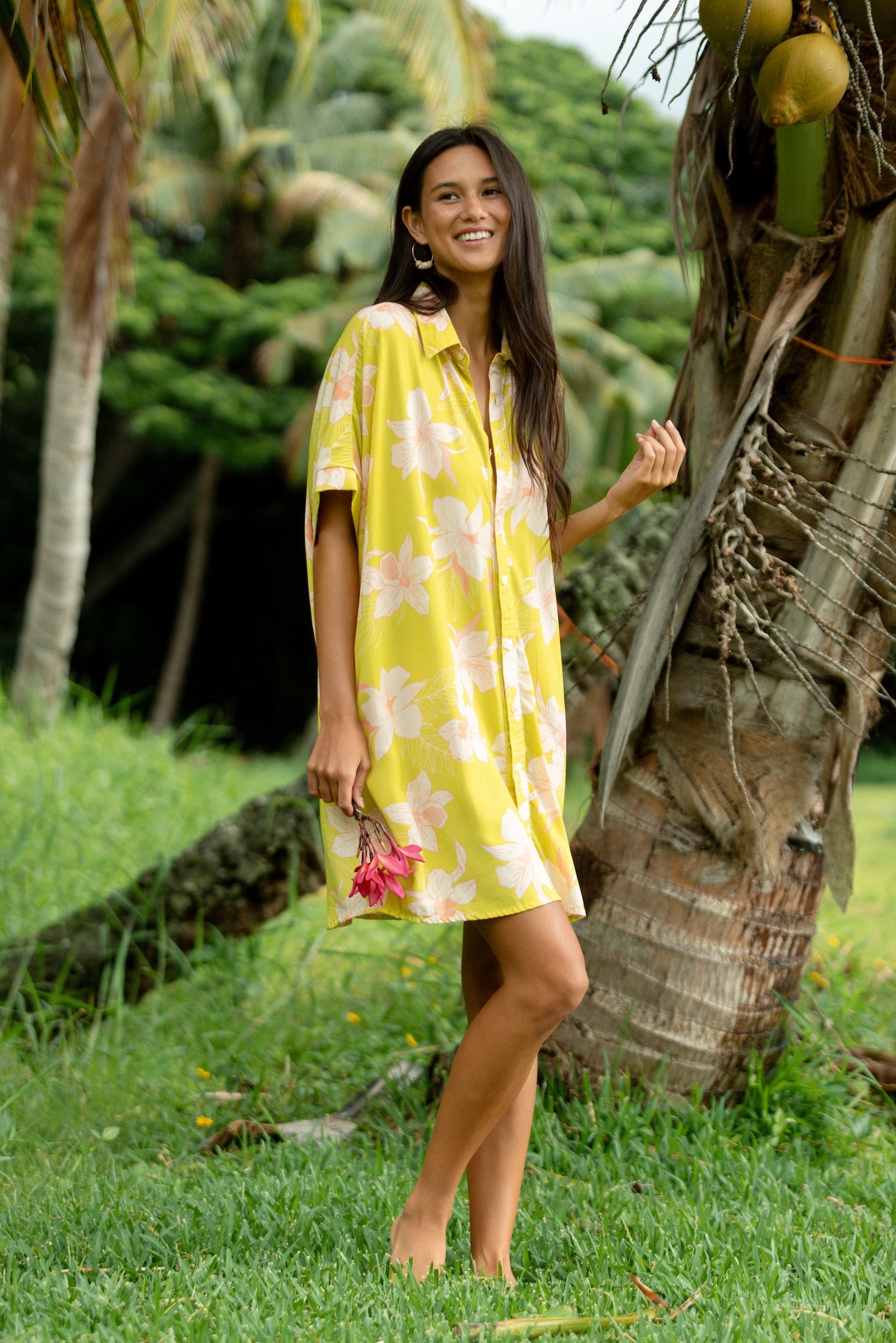 woman wearing a bright green button up dress with orchid print 