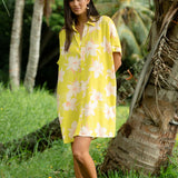 woman wearing a bright green button up dress with orchid print 