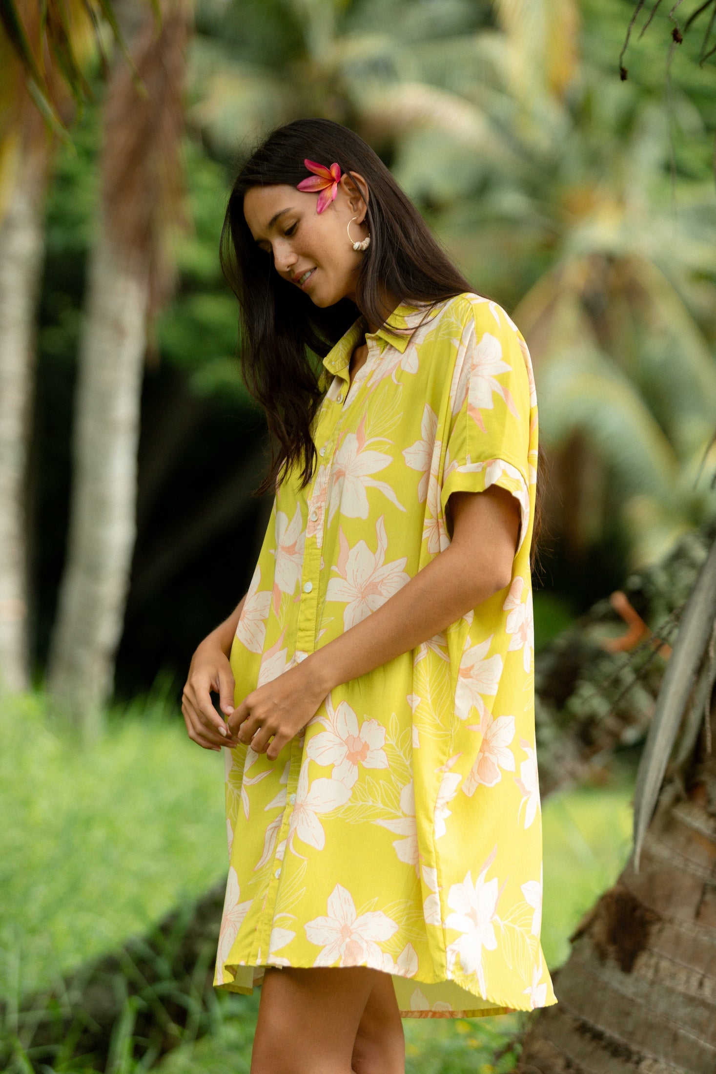 woman wearing a bright green button up dress with orchid print 