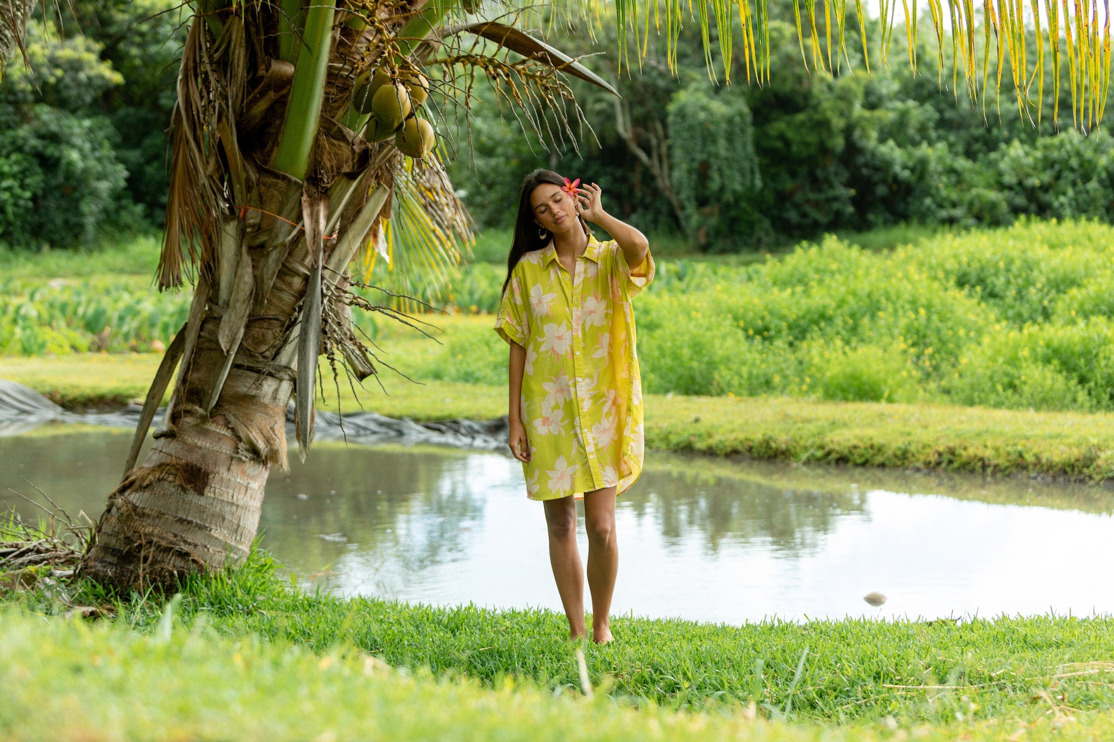woman wearing a bright green button up dress with orchid print 