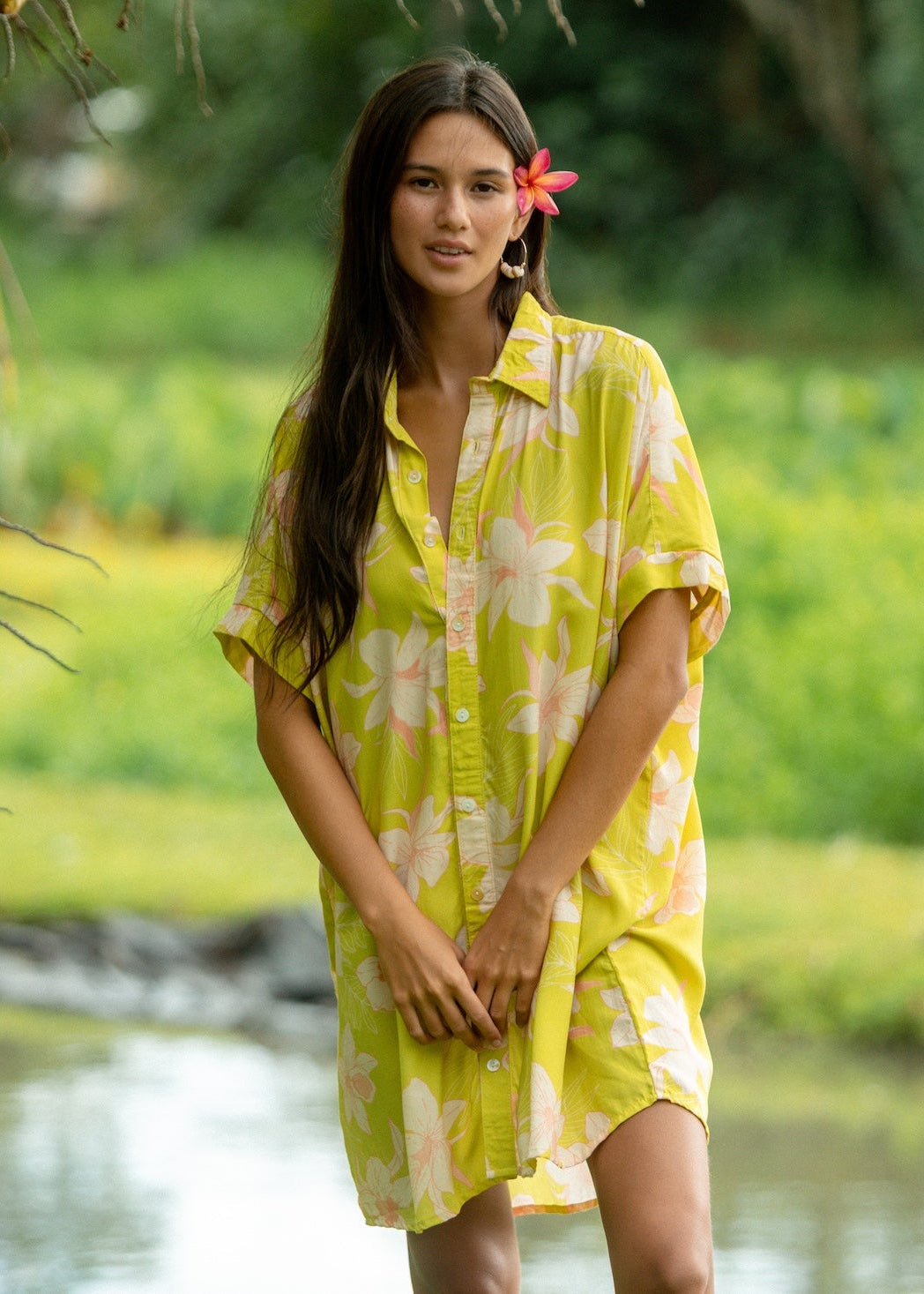 woman wearing a bright green button up dress with orchid print 