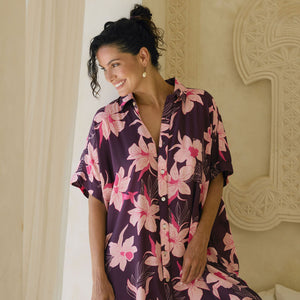 woman wearing an oversized button up shirt dress in dark purple color with orchid print