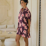 woman wearing an oversized button up shirt dress in dark purple color with orchid print