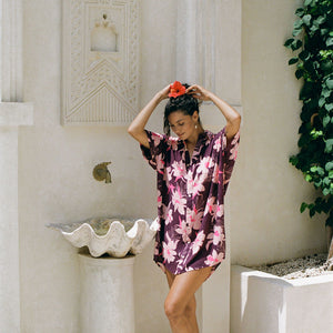 woman wearing an oversized button up shirt dress in dark purple color with orchid print