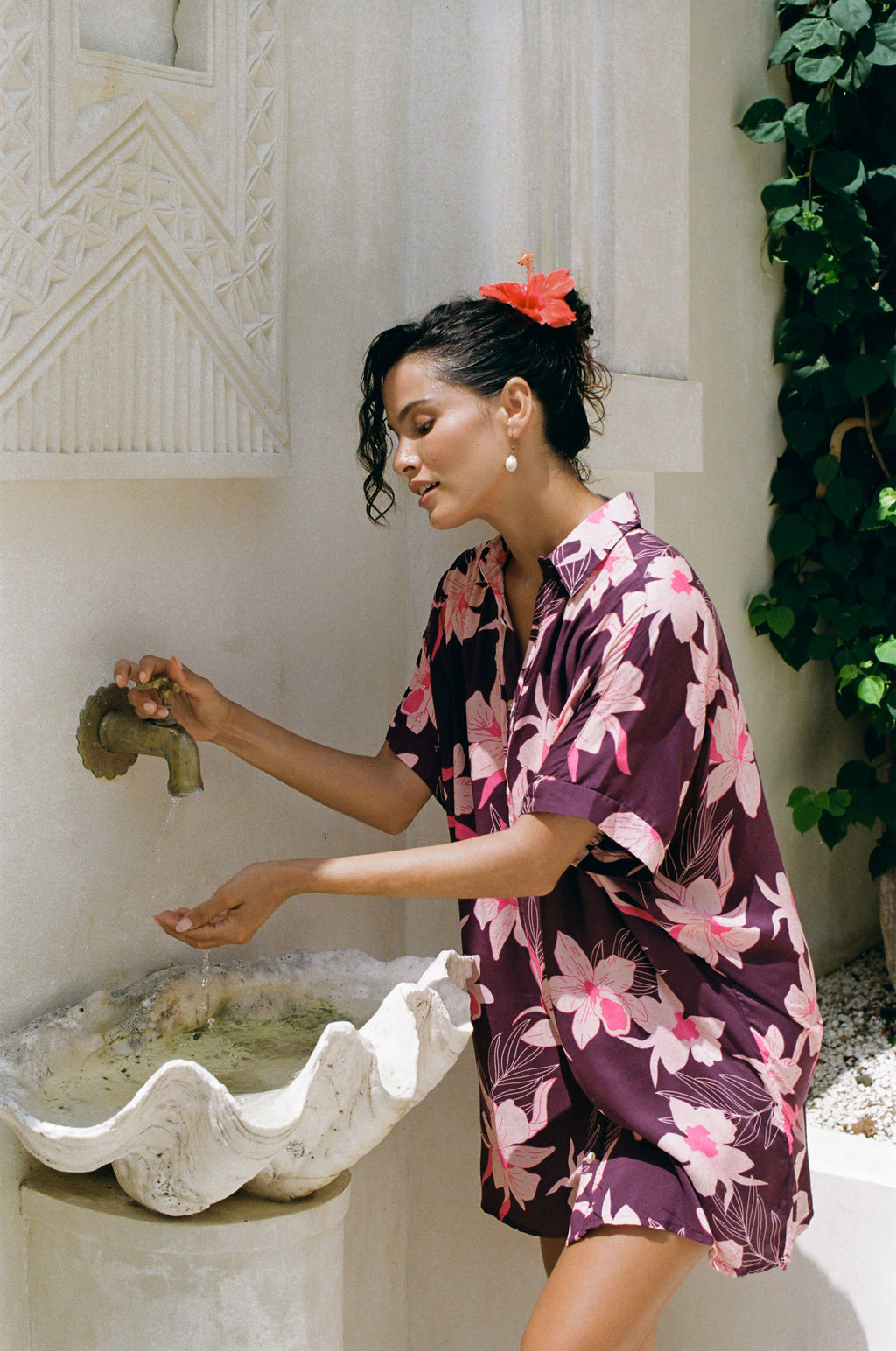 woman wearing an oversized button up shirt dress in dark purple color with orchid print