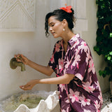 woman wearing an oversized button up shirt dress in dark purple color with orchid print