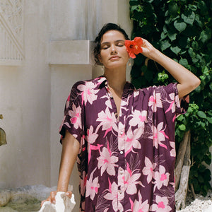 woman wearing an oversized button up shirt dress in dark purple color with orchid print