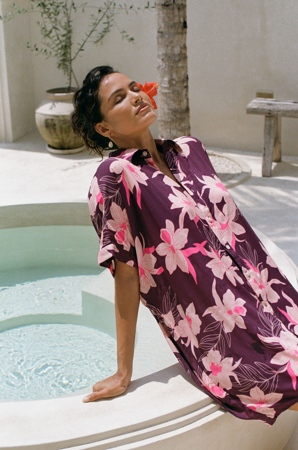 woman wearing an oversized button up shirt dress in dark purple color with orchid print