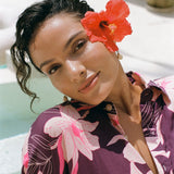 woman wearing an oversized button up shirt dress in dark purple color with orchid print